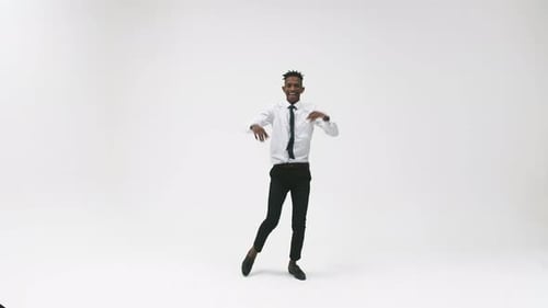 Black office man in a suit dancing smiling in the studio. Black male businessman happily dances