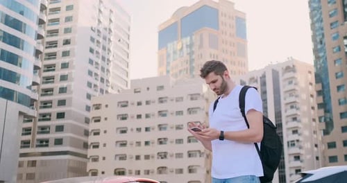 Man Using Phone in Urban City Setting