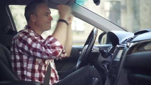 Side View of Cheerful Relaxed Happy Man Dancing Sitting on Driver's Seat in Automobile