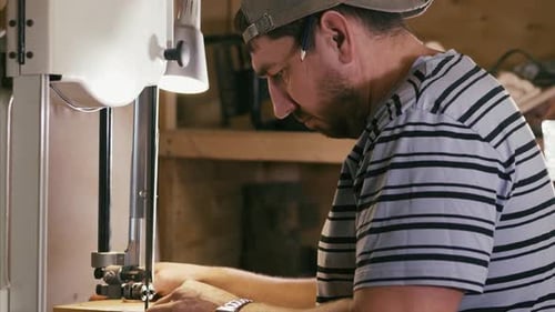 Adult Man Using Band Saw in Workshop