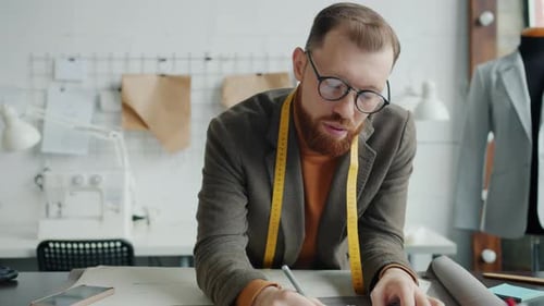 Fashion Designer Drawing Pattern in Studio