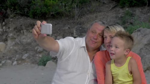 Grandparents and Grandson Smiling for a Beach Selfie