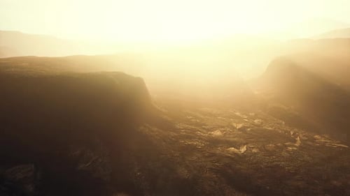 Aerial Flight Over Barren Alien Landscape with Bright Sun