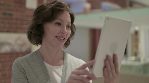 Woman Video Calling with Tablet Device Indoors