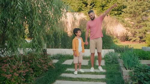 Father and Son Walking Through Garden Together