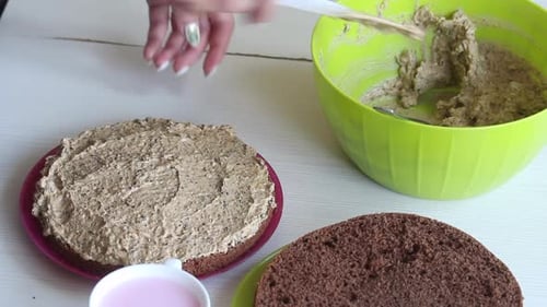 Hands Frosting a Chocolate Cake