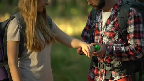 Man Applying Bug Spray to Woman in Forest