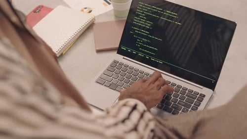 Typing Code on Laptop at Workplace