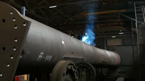 Arbeiter beim Schweißen von Metallkonstruktionen in Werkstatt