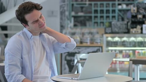 Creative Man with Laptop Having Neck Pain