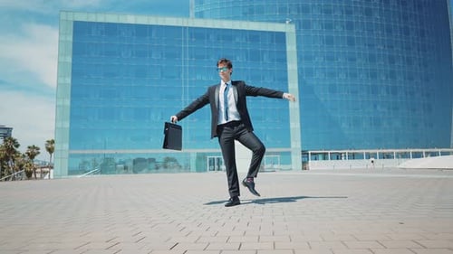 Flexible and cool businessman doing acrobatic tricks outdoor.