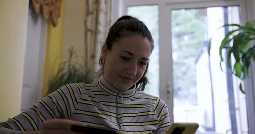Woman with mobile phone and credit card on the sofa making online purchases o