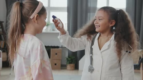 Giggling Girls Playing Doctor at Home