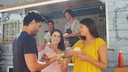 Smiling friends eating snacks