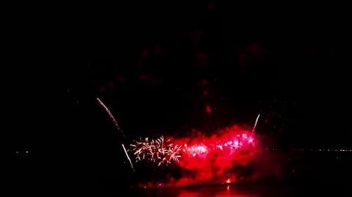 Colorful Fireworks Exploding over Water at Night
