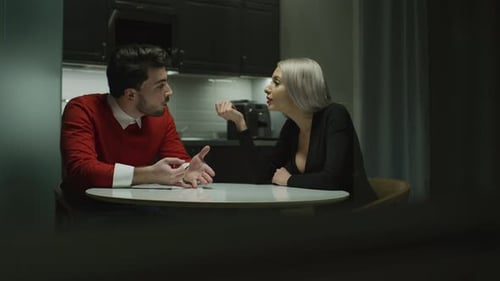 Man and Woman Talking at Kitchen Table