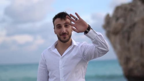 Man Waving Hello on a Beach