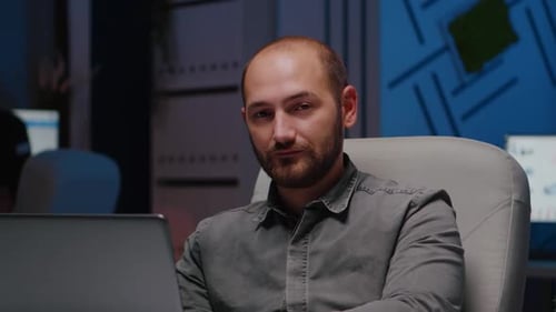 Young Adult Working on Laptop in Office at Night