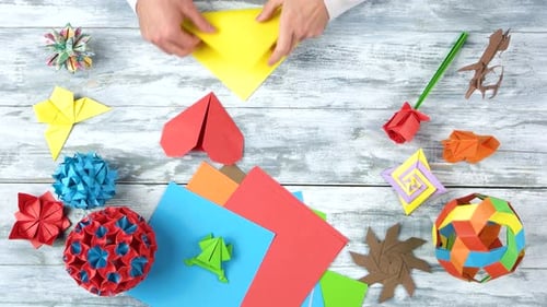 Man biegt Papier, um Origami herzustellen