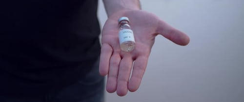 Hand Holding Vaccine Vial for Medical Use