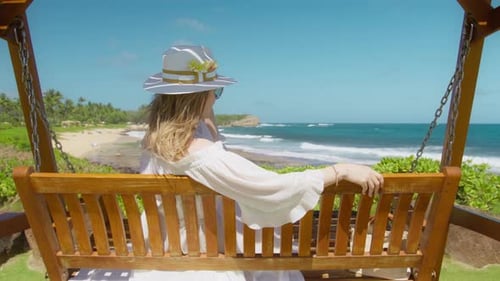 Woman Enjoying Beach View from a Wooden Swing