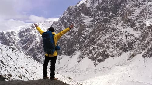 Tourist on Mountain Top. Sport and Active Life. Hiker with Backpack Standing on Top of a Mountain