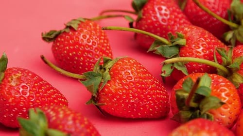 Bright red and sweet ripe many strawberries on red background.