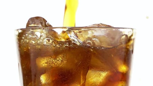 Pouring Cold Drink into Glass with Ice