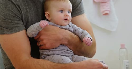 Dad Holding Adorable Baby in Bright Room