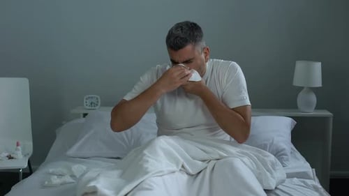 Man Having Seasonal Allergy, Sneezing in Bed, Needs Antihistamines, Health Care