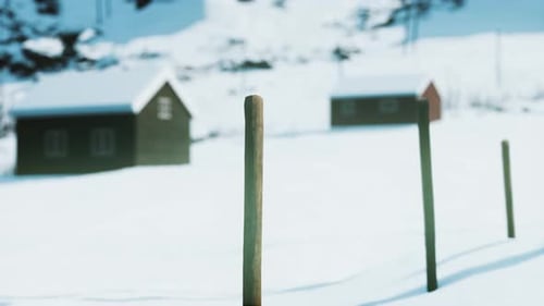 Winter Landscape with Snow-Covered Houses and Wooden Posts