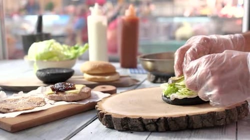 Gloved Hands Making a Burger in a Restaurant