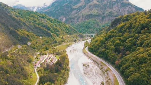 Flying Over a Mountain Winding Highway Near a Mountain Stream