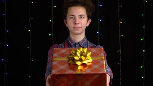 Young Adult Offering Christmas Gift with Festive Lights