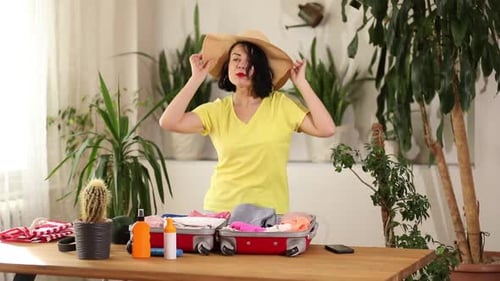 Stylish Woman Dancing and Packing Suitcase for Travel