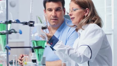 Biochemie-Wissenschaftlerin zeigt ihrer Assistentin eine Probe