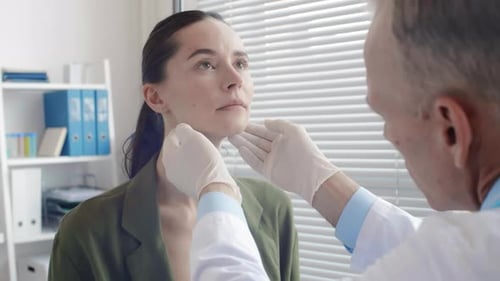 Doctor Examining Woman's Neck in Office Setting