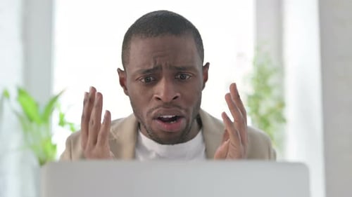 Close Up of African Man Reacting to Loss on Laptop