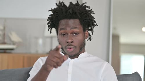 Smiling Man Gesturing Invitation Indoors