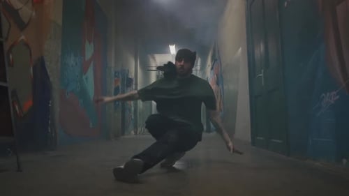 Young Adult Breakdancing in Graffiti Hallway