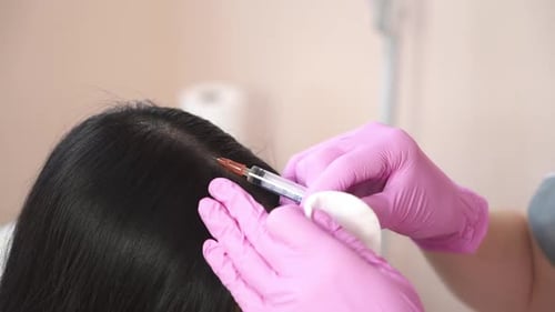 Woman receives an injection in the scalp. Problems of hair loss The concept of health.