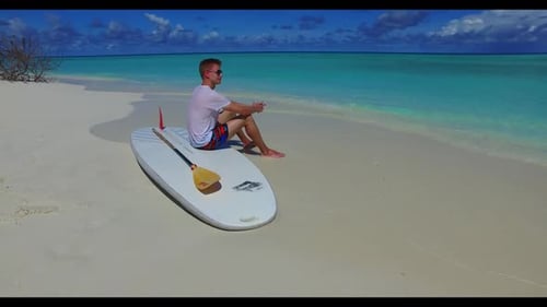 Two people sunbathe on tranquil sea view beach time by turquoise ocean and white sandy background of