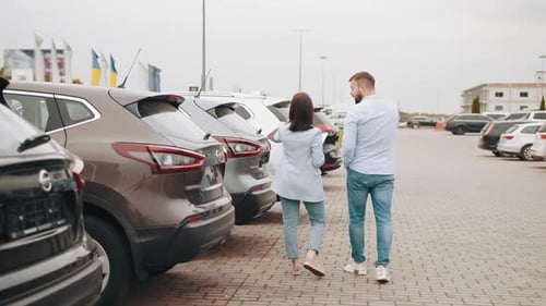 Man and Woman Looking at Cars on Car Lot