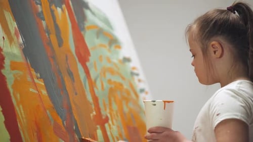 Young Girl Painting on Canvas in Art Studio