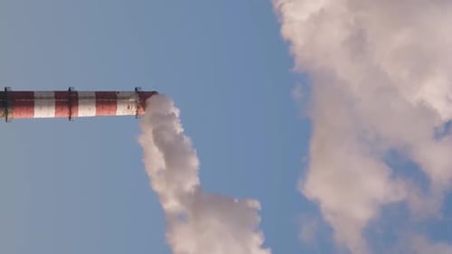 Industrial Smokestack Emitting Smoke Against Blue Sky