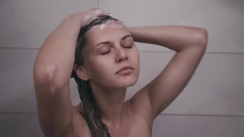 Woman Shampooing Hair in Shower at Home