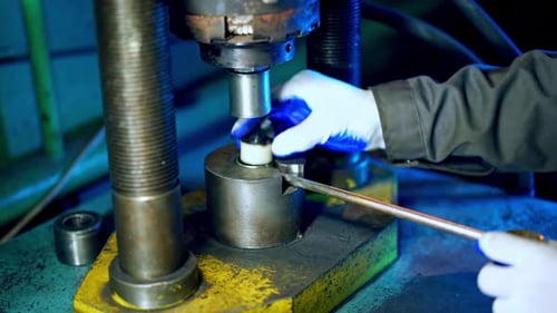 Industrial worker on metal press machine. Worker operating metal press machine at workshop