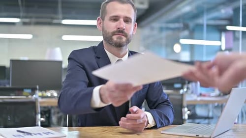 Ambitious Young Businessman Receiving Documents in Office