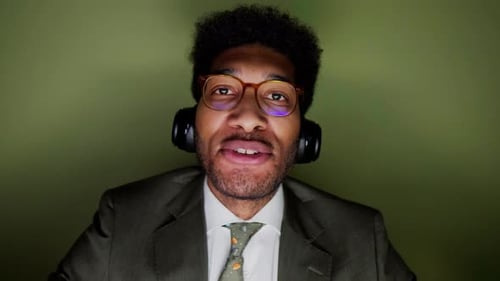 Smiling Man Wearing Headphones Speaking to Camera