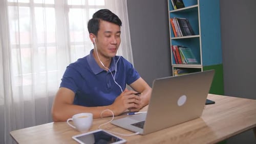 Young Man Attends Virtual Meeting from Home Office